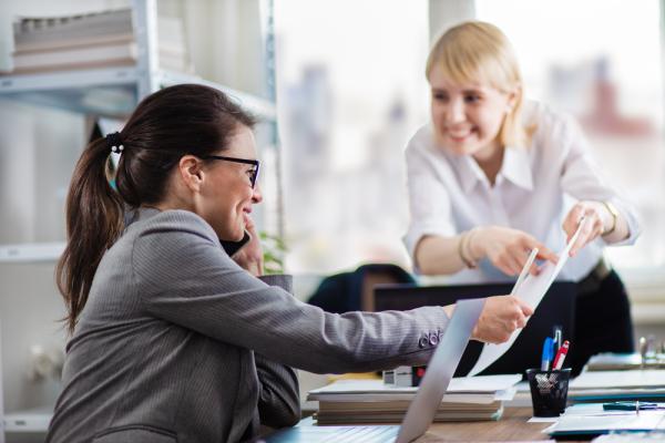Two women in an office chat about the best edtech companies to work for