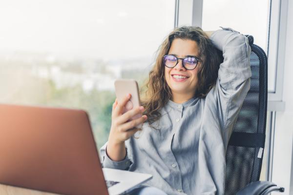 A young woman sits in front of a computer and chats on a video call with a student advisor from a self paced online college