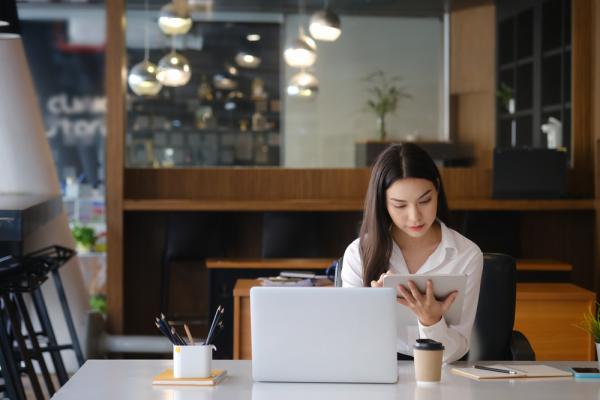 A business woman sitting in a cafe enjoys the benefits of online learning after work