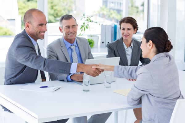 A young businesswoman meets with three business professionals to interview for a job