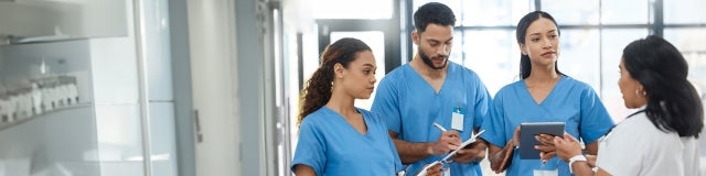 A group of new nurse graduates listens intently as they acclimate to their new roles.